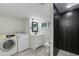 Modern bathroom with a black herringbone tile shower, white vanity, and convenient washer and dryer at 1716 N 32Nd Pl, Phoenix, AZ 85008