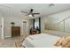 Bright bedroom featuring a dresser, large painting, ceiling fan, and view into ensuite bathroom at 1716 N 32Nd Pl, Phoenix, AZ 85008