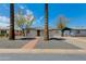 Charming single-story home with xeriscape front yard, complemented by a brick pathway and mature palm trees at 1716 N 32Nd Pl, Phoenix, AZ 85008