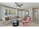 Comfortable living room with a plush sectional, pink chair, and large windows with plantation shutters at 1716 N 32Nd Pl, Phoenix, AZ 85008