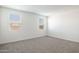A bright bedroom with carpet and two windows with blinds at 17813 W Mission Ln, Waddell, AZ 85355