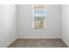 Clean bedroom with neutral carpeting, base molding, and a window letting in natural light at 17813 W Mission Ln, Waddell, AZ 85355