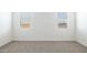 Spacious bedroom features neutral carpet and natural light from two windows at 17813 W Mission Ln, Waddell, AZ 85355