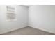 An empty bedroom featuring neutral colored walls and carpet with a window at 17813 W Mission Ln, Waddell, AZ 85355