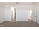 A bright bedroom with carpet and an entrance to the bathroom with glass door shower at 17813 W Mission Ln, Waddell, AZ 85355