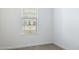 Clean bedroom with neutral carpeting, base molding, and a window letting in natural light at 17813 W Mission Ln, Waddell, AZ 85355