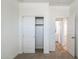 Bedroom featuring carpet, closet with white sliding doors, and an open doorway to a hall at 17813 W Mission Ln, Waddell, AZ 85355