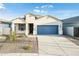 Charming single-story home featuring a blue garage door, well-manicured landscaping, and a welcoming entrance at 17813 W Mission Ln, Waddell, AZ 85355