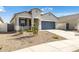 Beautiful single-story home featuring manicured desert landscaping, inviting curb appeal and a gray garage door at 17813 W Mission Ln, Waddell, AZ 85355