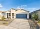 Inviting home with a clean facade, desert landscaping, and a spacious driveway leading to a blue garage door at 17813 W Mission Ln, Waddell, AZ 85355