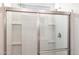 Shower featuring sliding glass doors, sleek fixtures, and built-in shelving at 17813 W Mission Ln, Waddell, AZ 85355