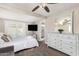 Comfortable bedroom featuring an updated ceiling fan, dresser, and an ensuite bathroom at 1934 E El Parque Dr, Tempe, AZ 85282