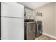 Functional laundry room with stainless steel washer and dryer, and an extra refrigerator at 1934 E El Parque Dr, Tempe, AZ 85282