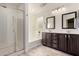 Well-lit bathroom with glass shower, soaking tub, and dual sink vanity for ultimate convenience at 2108 E Lindrick Dr, Gilbert, AZ 85298