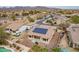 Aerial view of the home featuring solar panels, an enclosed patio, and a well-manicured backyard at 22065 W Twilight Trl, Buckeye, AZ 85326