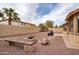 Backyard showcasing desert landscaping, fire pit, and shed against a privacy wall at 22065 W Twilight Trl, Buckeye, AZ 85326