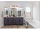 Bathroom with double sinks, large mirror, granite countertops and a garden tub at 22065 W Twilight Trl, Buckeye, AZ 85326