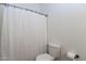 Bathroom featuring white toilet and white shower curtain with simple decor at 22065 W Twilight Trl, Buckeye, AZ 85326