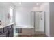 Bathroom with large tub, glass shower, and double sink vanity at 22065 W Twilight Trl, Buckeye, AZ 85326