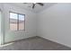 Simple bedroom with window and ceiling fan, neutral paint and carpeting at 22065 W Twilight Trl, Buckeye, AZ 85326