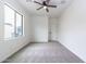 Bright bedroom featuring neutral carpet, a ceiling fan, a window and a door to compliment the space at 22065 W Twilight Trl, Buckeye, AZ 85326