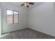 Bright bedroom with cozy carpeting, ceiling fan, and view of the outside at 22065 W Twilight Trl, Buckeye, AZ 85326