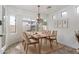 Bright dining room with large windows, tan rug and modern chandelier at 22065 W Twilight Trl, Buckeye, AZ 85326