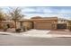 Inviting single-story home with desert landscaping and a spacious driveway leading to a two-car garage at 22065 W Twilight Trl, Buckeye, AZ 85326