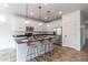 Modern kitchen featuring white cabinetry, stainless steel appliances, and an island with barstool seating at 22065 W Twilight Trl, Buckeye, AZ 85326