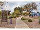 Windmill Village's playground features a walkway, trees, and lush grassy areas for children to enjoy at 22065 W Twilight Trl, Buckeye, AZ 85326