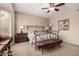 Charming bedroom with iron bed frame, ceiling fan, and natural light from the window at 23935 S Sunvista Dr, Sun Lakes, AZ 85248