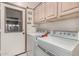 Functional laundry area with washer, dryer, storage cabinets, and direct access to the outside at 23935 S Sunvista Dr, Sun Lakes, AZ 85248