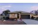 Charming single-story home with brick accents, neutral stucco, a tile roof, and a well-manicured desert landscape at 25161 W Wayland Dr, Buckeye, AZ 85326