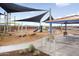 View of a playground and park with picnic tables, climbing structure, and sunshades at 25161 W Wayland Dr, Buckeye, AZ 85326