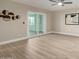 Inviting living room with light wood flooring, modern ceiling fan, and sliding glass doors to the patio at 2563 N Doral Cir, Mesa, AZ 85215