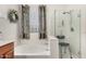 Well-lit bathroom featuring tub, separate glass shower and a privacy window at 273 S 152Nd Ave, Goodyear, AZ 85338