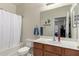 Bright bathroom with a white sink, wooden vanity, and neutral wall color at 273 S 152Nd Ave, Goodyear, AZ 85338