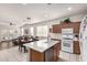 Bright kitchen featuring an island with sink, white countertops, gas range oven and adjacent dining and living area at 273 S 152Nd Ave, Goodyear, AZ 85338