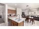 Open-concept kitchen features island with sink, stainless steel dishwasher, and easy access to the dining and living areas at 273 S 152Nd Ave, Goodyear, AZ 85338