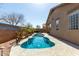 Backyard pool with a unique shape, surrounded by desert landscaping and a spacious patio, perfect for outdoor enjoyment at 273 S 152Nd Ave, Goodyear, AZ 85338