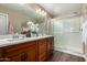 A bathroom with a double sink vanity, large mirror, and a glass-enclosed shower at 2821 S Skyline Dr # 107, Mesa, AZ 85212