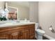 This half bath features a wooden cabinet, white countertop, and a decorative mirror with flower decor at 2821 S Skyline Dr # 107, Mesa, AZ 85212