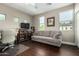 A cozy bedroom with a gray sofa, tv on a stand, neutral paint and a window with natural light at 2821 S Skyline Dr # 107, Mesa, AZ 85212