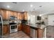 An expansive kitchen with stainless appliances, granite counters, wooden cabinetry, and hardwood flooring at 2821 S Skyline Dr # 107, Mesa, AZ 85212