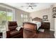 This main bedroom features a ceiling fan, dark wood floors, a cozy chair and a sliding door at 2821 S Skyline Dr # 107, Mesa, AZ 85212