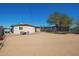 Wide view of the backyard including patio seating, a trampoline and a small playhouse at 3009 N 81St Ln, Phoenix, AZ 85033
