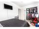 Spacious bedroom featuring a closet, black bedding, wall mounted TV, and tile flooring at 3009 N 81St Ln, Phoenix, AZ 85033