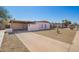 A single-story home with a covered carport and desert landscaping under a clear blue sky at 3009 N 81St Ln, Phoenix, AZ 85033
