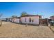 Cozy single-story home with a covered carport and desert landscaping with a dog at 3009 N 81St Ln, Phoenix, AZ 85033