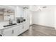 Bright kitchen featuring white cabinets, stainless steel sink, and gray wood-look flooring at 3009 N 81St Ln, Phoenix, AZ 85033